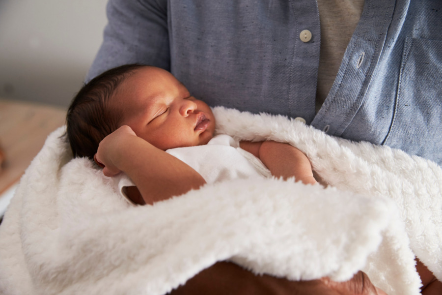 Close up of baby held in father's arms