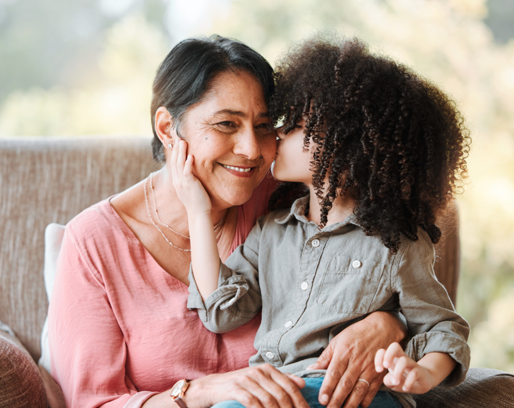 Grandchild kissing her grandmother on the cheek