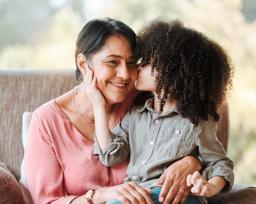 Grandchild kissing her grandmother on the cheek